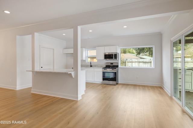 unfurnished living room with ornamental molding and light hardwood / wood-style flooring