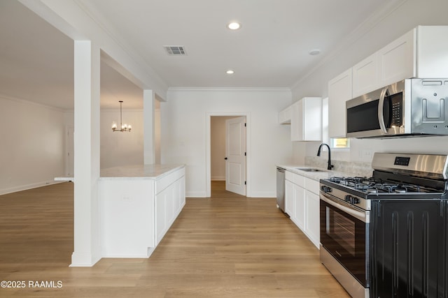 kitchen with sink, white cabinetry, crown molding, light wood-type flooring, and stainless steel appliances