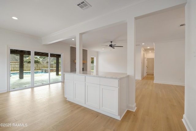 kitchen with white cabinetry, ornamental molding, ceiling fan, and light wood-type flooring