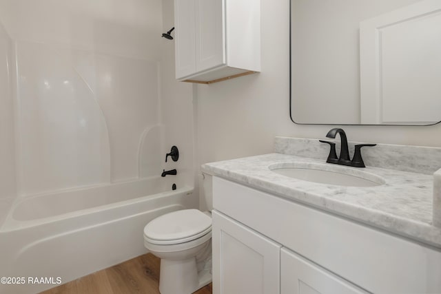 full bathroom featuring wood-type flooring, toilet, bathing tub / shower combination, and vanity