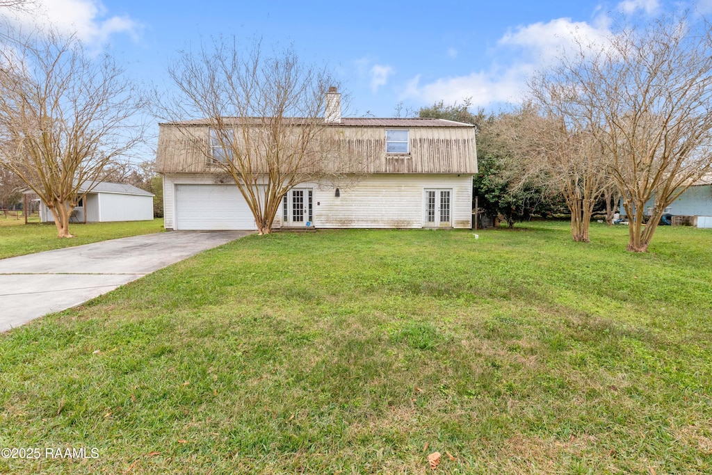 view of front facade with french doors, a front lawn, and a garage