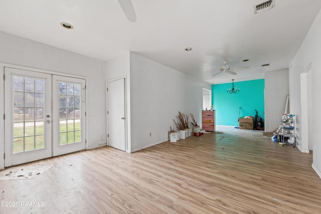 unfurnished living room with ceiling fan, french doors, and light hardwood / wood-style floors