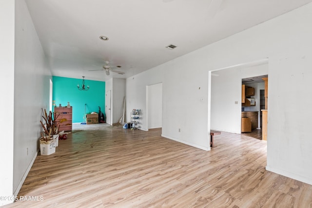 unfurnished living room with light wood-type flooring and ceiling fan with notable chandelier