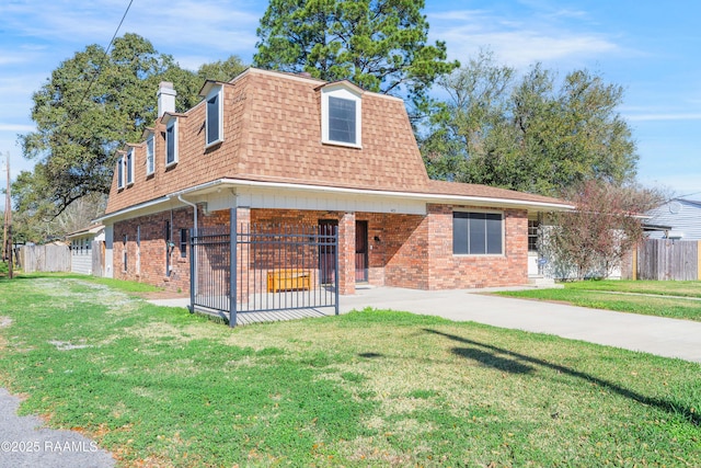 front facade featuring roof with shingles, mansard roof, a front lawn, and brick siding