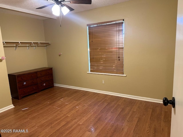 unfurnished bedroom with a closet, ceiling fan, a textured ceiling, and hardwood / wood-style flooring