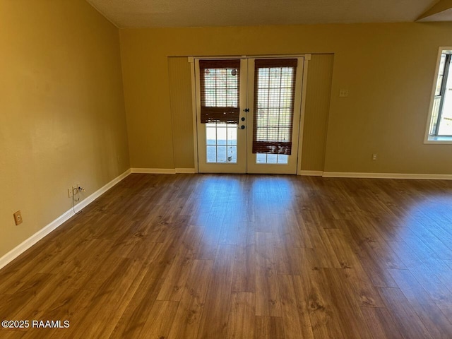 spare room featuring french doors and dark hardwood / wood-style floors