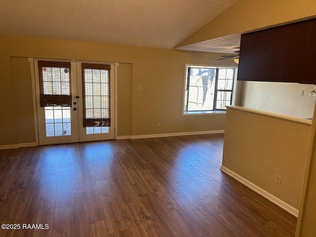 spare room featuring a textured ceiling, lofted ceiling, french doors, dark hardwood / wood-style floors, and ceiling fan