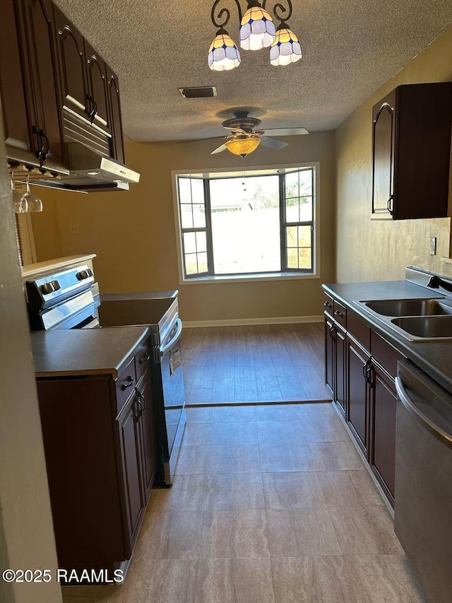 kitchen with a textured ceiling, appliances with stainless steel finishes, sink, ceiling fan, and dark brown cabinets