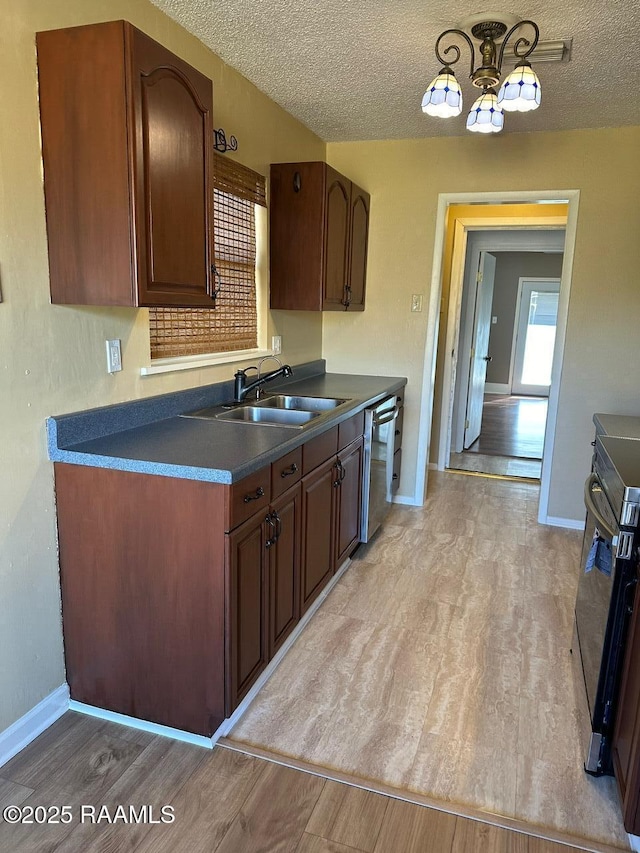 kitchen featuring sink, dishwasher, stove, and a textured ceiling