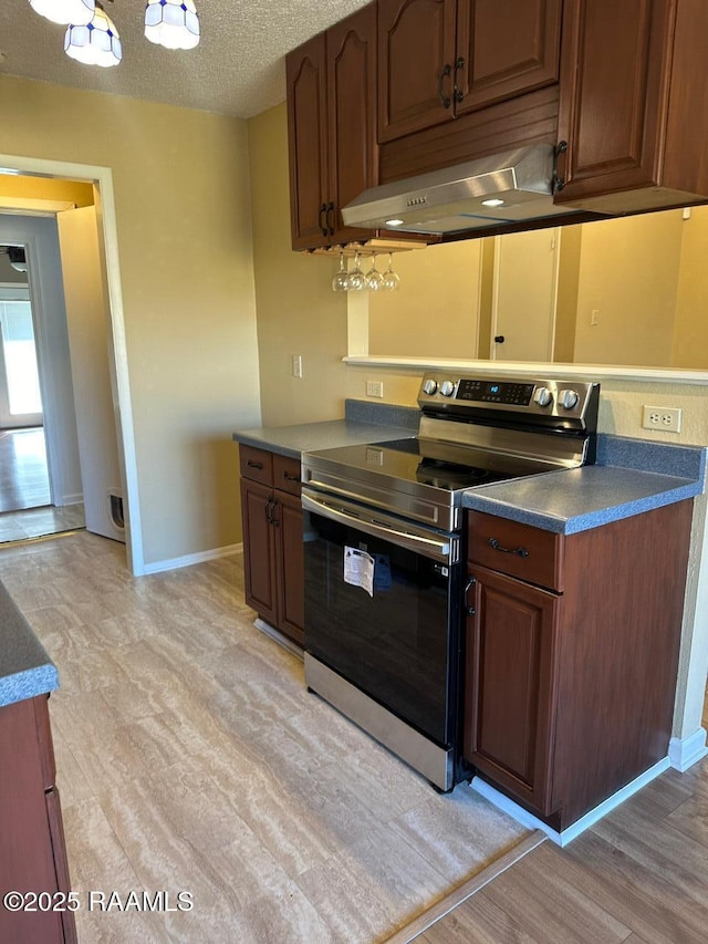 kitchen with stainless steel electric stove, a textured ceiling, and light hardwood / wood-style flooring