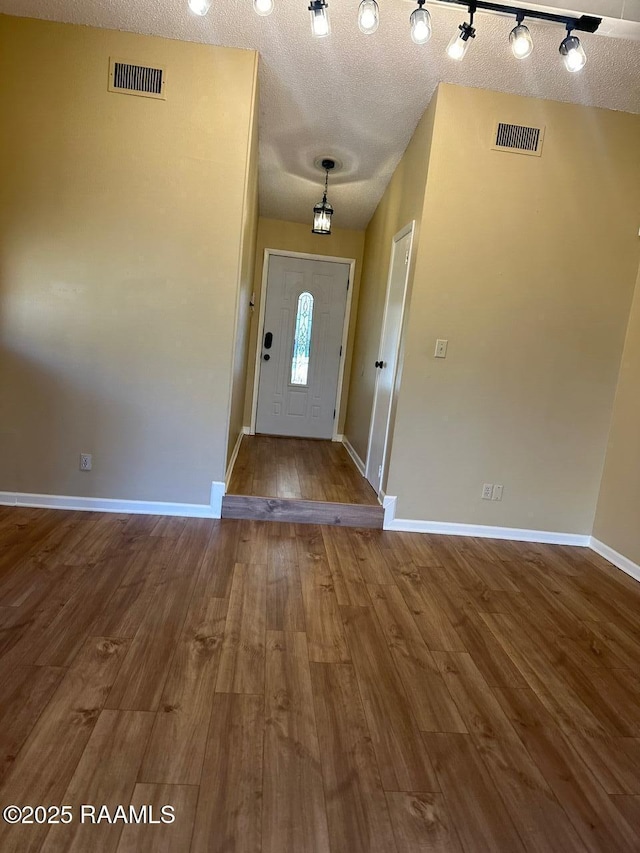 entryway featuring hardwood / wood-style flooring and a textured ceiling