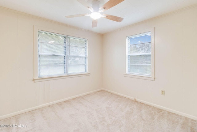 carpeted empty room featuring ceiling fan and crown molding