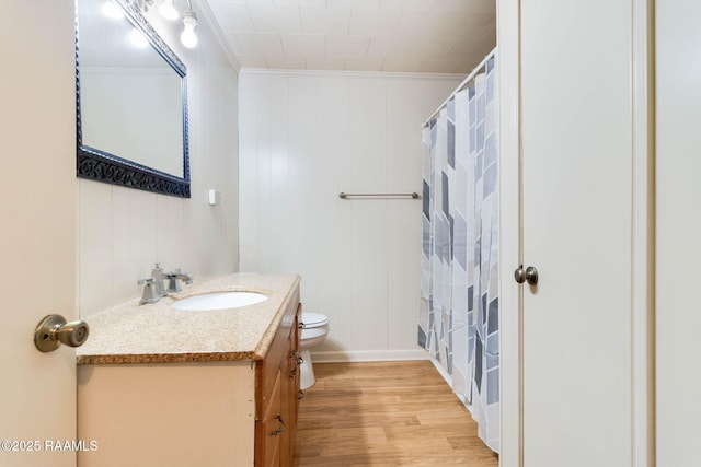 bathroom with toilet, vanity, hardwood / wood-style flooring, and crown molding