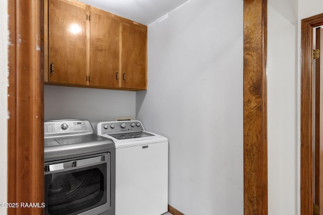 washroom featuring cabinets and washing machine and dryer