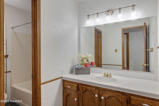 full bathroom with tile walls, shower / tub combination, vanity, and toilet