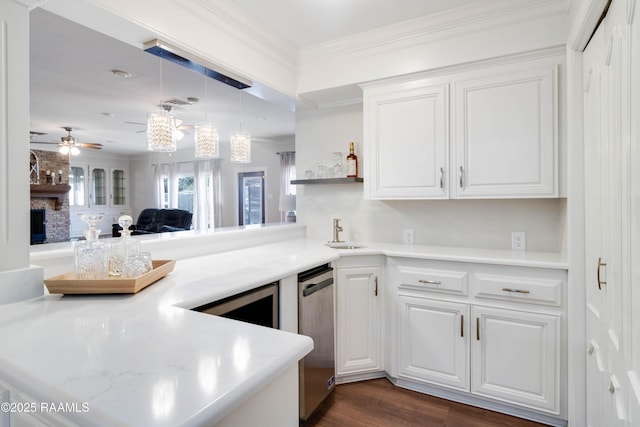 kitchen with white cabinets, a fireplace, ceiling fan, and kitchen peninsula