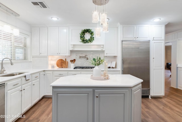 kitchen featuring appliances with stainless steel finishes, pendant lighting, a center island, and sink