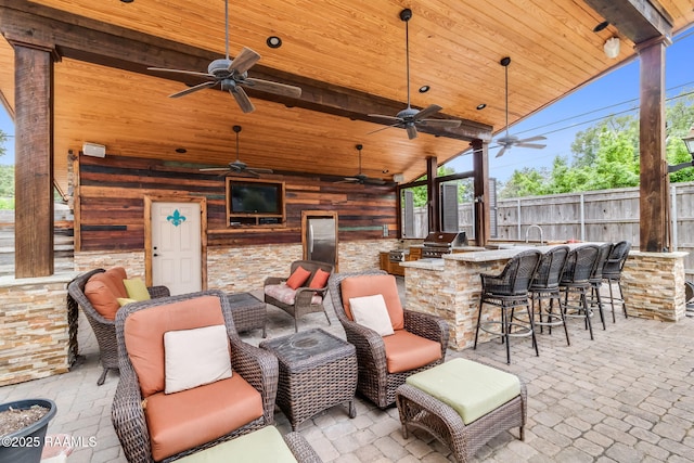 view of patio with a bar, ceiling fan, and area for grilling