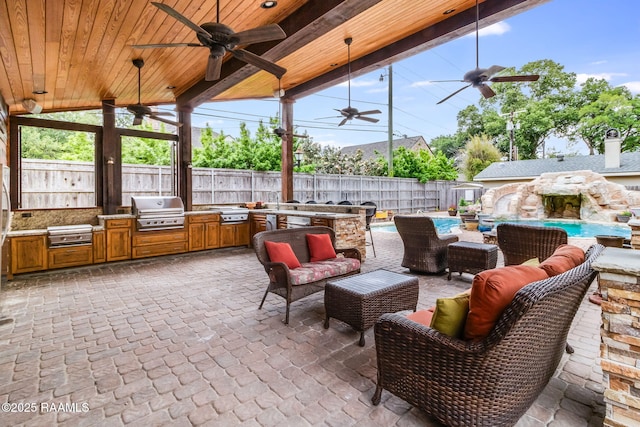 view of patio featuring exterior kitchen, an outdoor living space, ceiling fan, and area for grilling