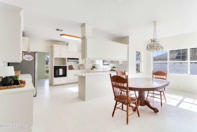 dining space with plenty of natural light, a textured ceiling, and a chandelier