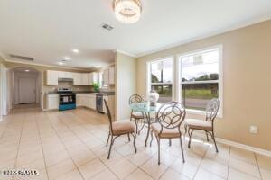 dining room with light tile patterned floors and ornamental molding