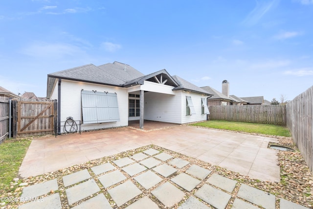 rear view of house featuring a lawn and a patio