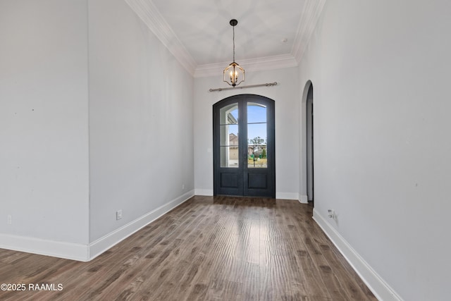 entrance foyer with hardwood / wood-style floors, crown molding, french doors, and an inviting chandelier