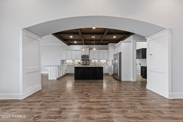 kitchen with dark hardwood / wood-style floors, a kitchen island, beamed ceiling, coffered ceiling, and appliances with stainless steel finishes