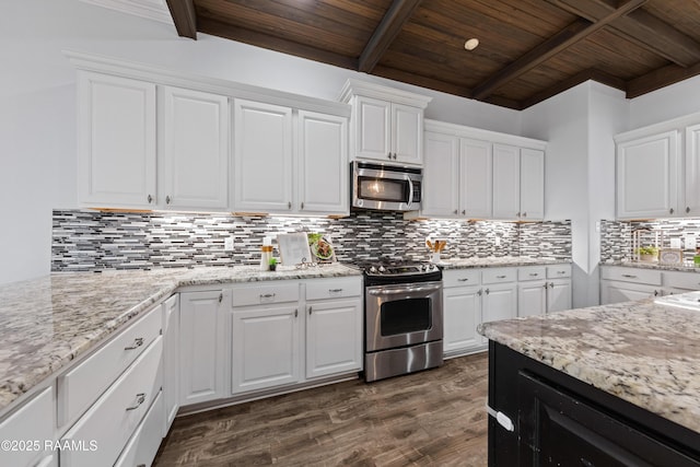 kitchen featuring appliances with stainless steel finishes, beamed ceiling, and white cabinetry