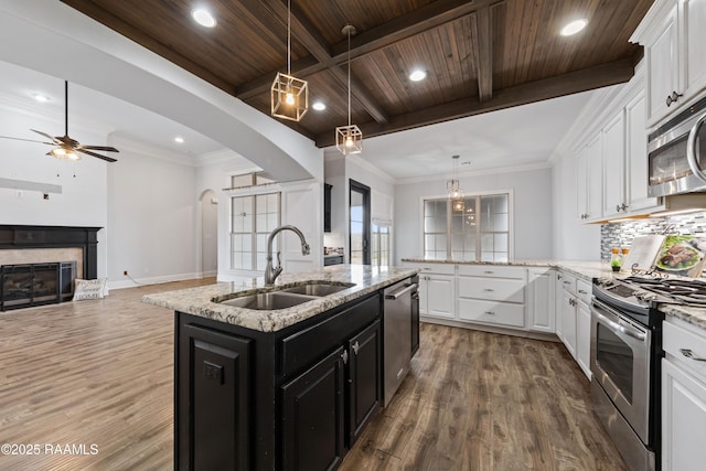 kitchen featuring white cabinets, appliances with stainless steel finishes, wood ceiling, sink, and a kitchen island with sink