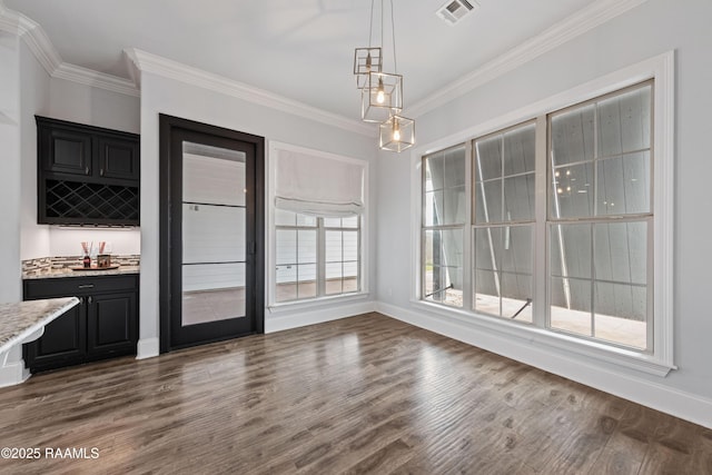 unfurnished dining area with crown molding, dark hardwood / wood-style flooring, and bar