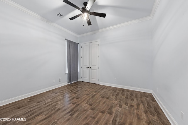 empty room featuring ceiling fan, dark wood-type flooring, and ornamental molding