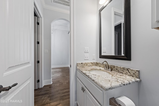 bathroom with ornamental molding, wood-type flooring, and vanity