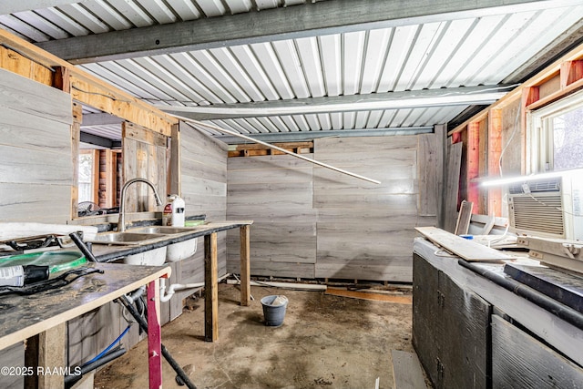 interior space with sink, concrete floors, and wood walls