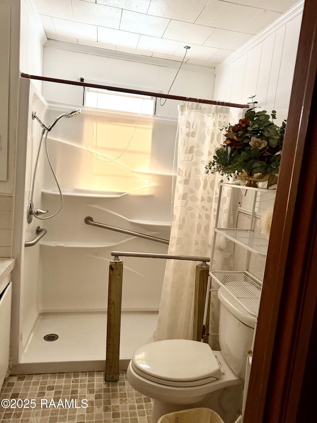 bathroom with toilet, crown molding, and a shower with shower curtain