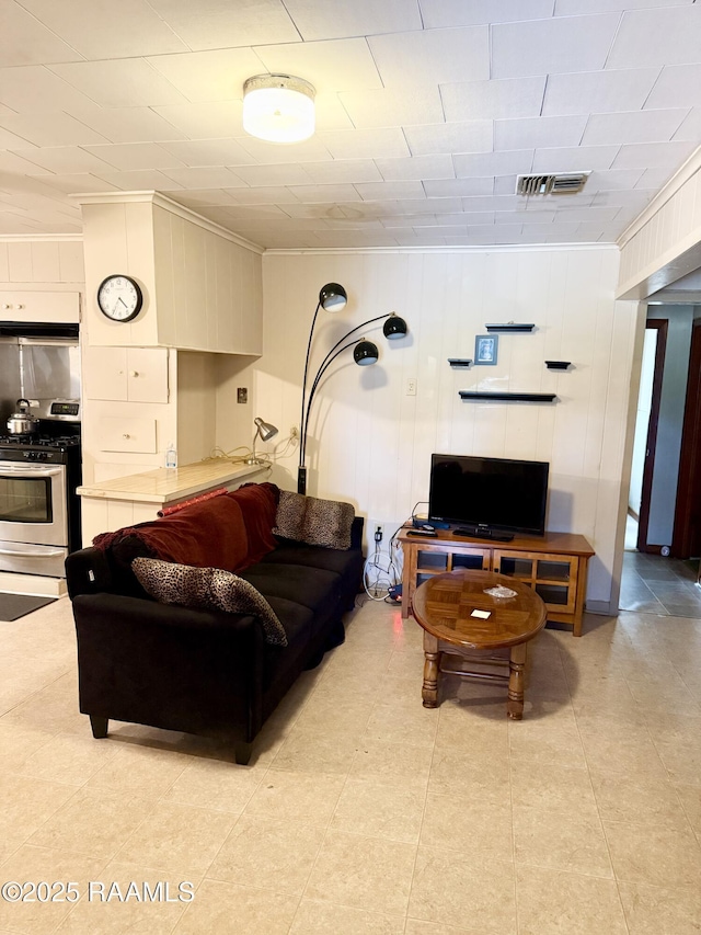 living room featuring wooden walls and ornamental molding