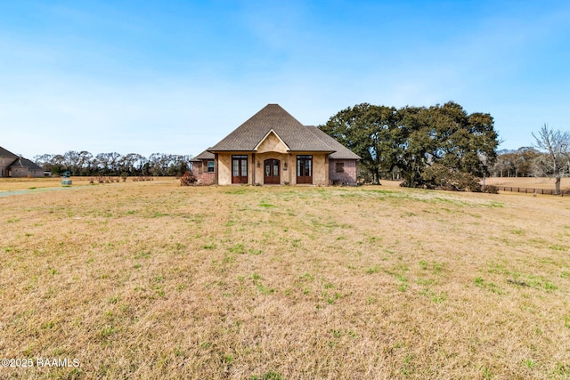 view of front of property with a front lawn and a rural view