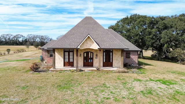 241 Lana Rd, Opelousas, LA 70570 - view of front of house with french doors, a front lawn, a shingled roof, brick siding, and stucco siding