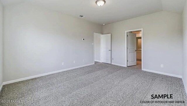 unfurnished bedroom featuring vaulted ceiling and carpet flooring