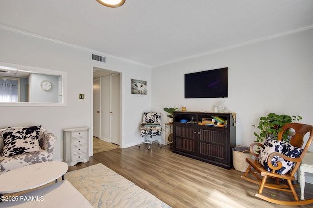 living room featuring light wood-type flooring and ornamental molding