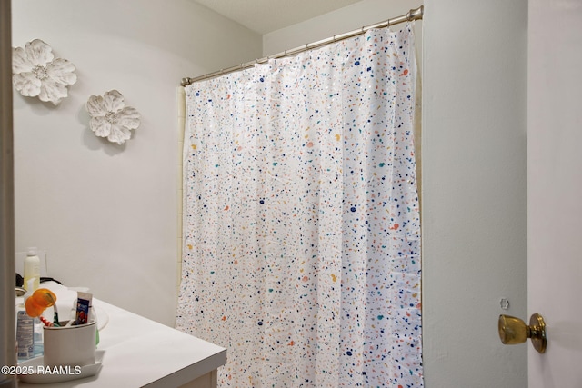 bathroom featuring vanity and curtained shower