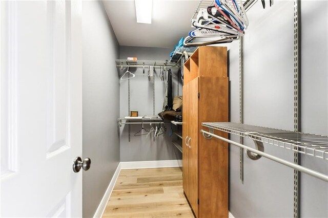 walk in closet with wood finished floors