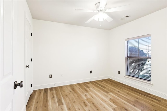 empty room with baseboards, visible vents, a ceiling fan, and light wood-style floors