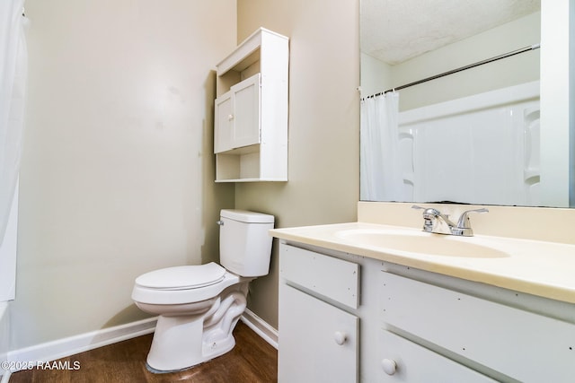 bathroom with wood-type flooring, toilet, vanity, and walk in shower