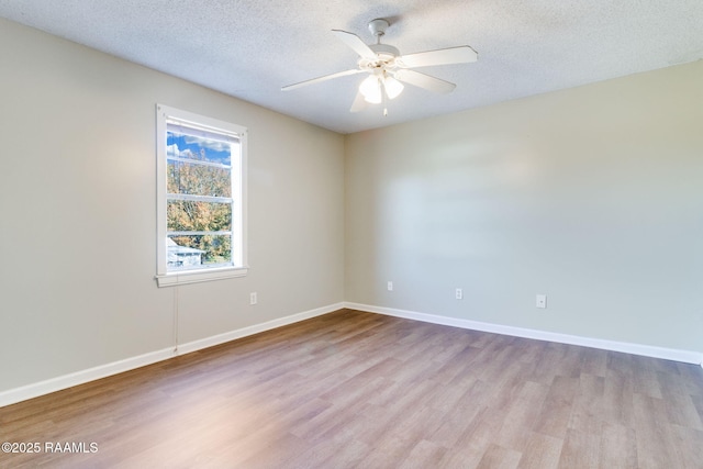 empty room with light wood-type flooring, ceiling fan, and a textured ceiling