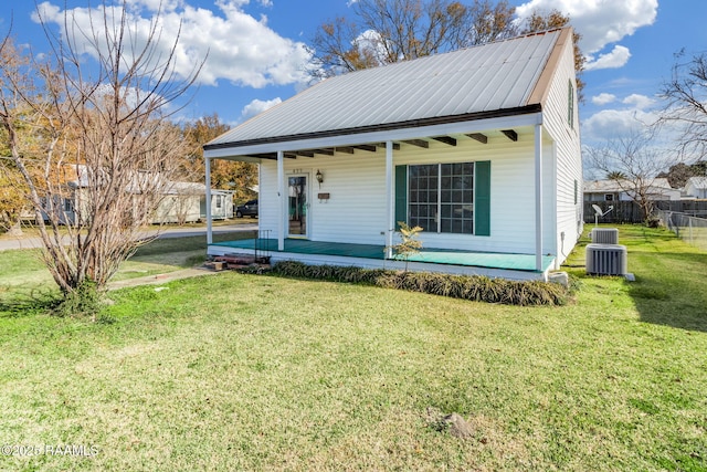 view of front of house with a front yard, a porch, and central air condition unit