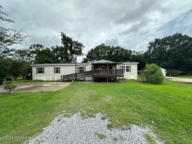 manufactured / mobile home featuring a wooden deck and a front yard