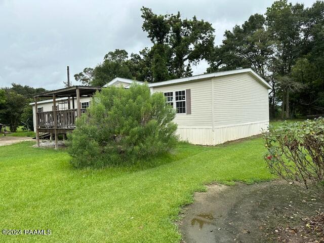 view of home's exterior with a deck and a lawn