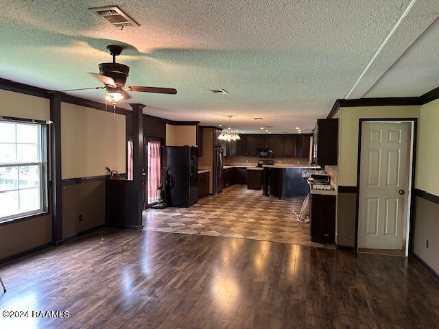 kitchen with a textured ceiling, ornamental molding, black appliances, ceiling fan with notable chandelier, and a center island