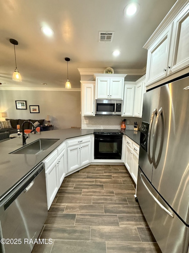 kitchen with white cabinetry, hanging light fixtures, sink, and appliances with stainless steel finishes